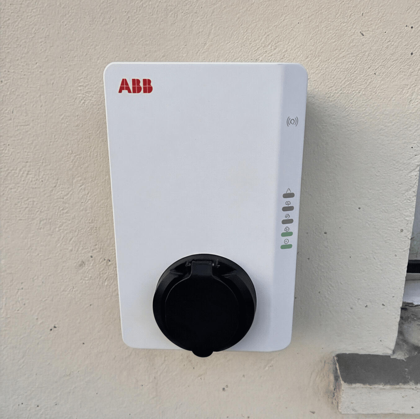 Borne de recharge installée sur un mur de garage à Caen